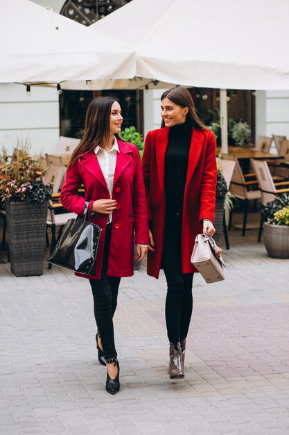 Dos chicas en modelos de abrigos rojos.