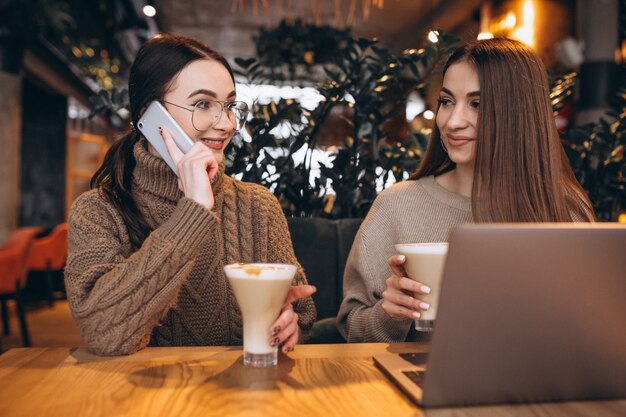 Dos chicas trabajando en una computadora en un café