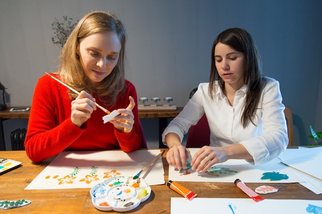 Dos chicas tranquilas disfrutando de la pintura simple.