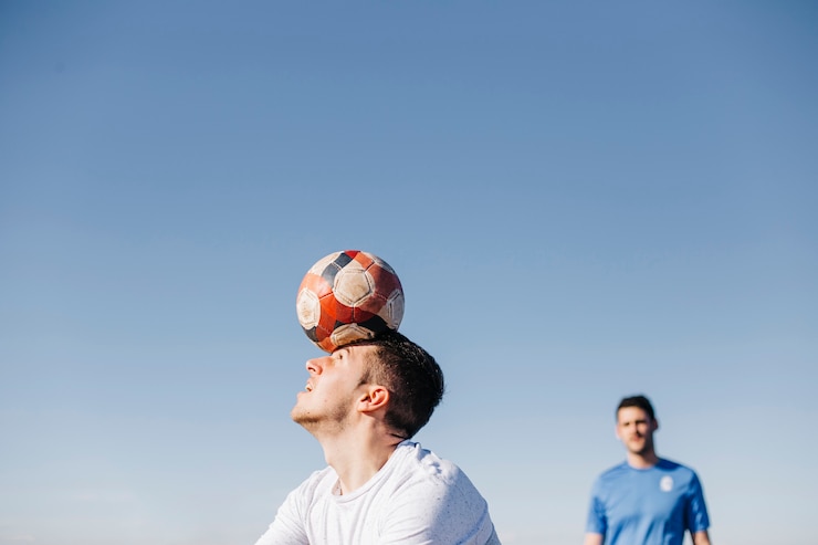 Foto gratuito dos chicos jugando al fútbol en la playa