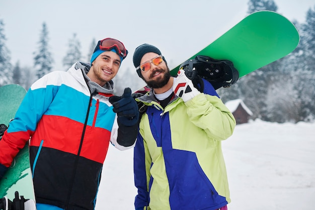 Dos chicos con tablas de snowboard durante las vacaciones de invierno