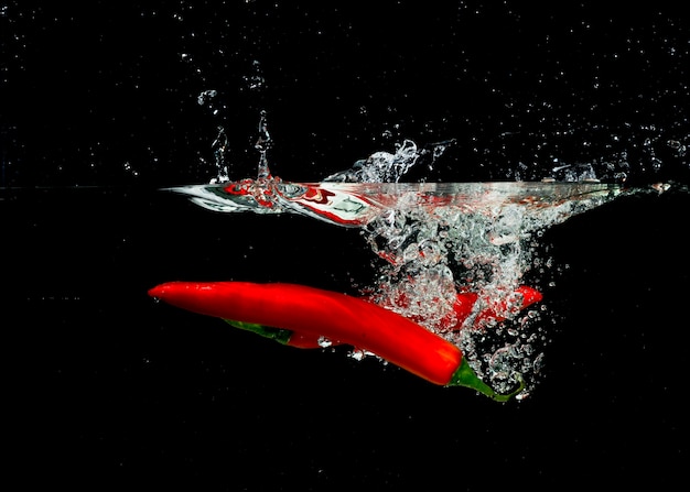 Foto gratuita dos chiles rojos chapoteando en agua clara