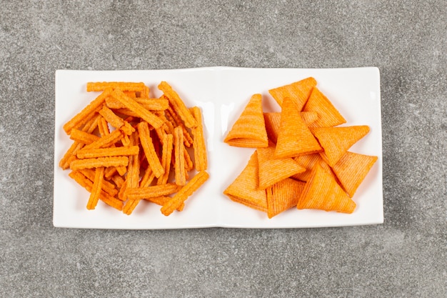 Foto gratuita dos chips de forma diferente en un plato blanco.