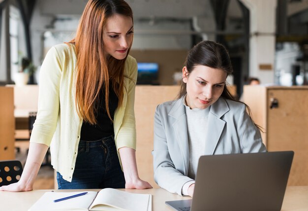 Dos colegas femeninas en la oficina trabajando juntos