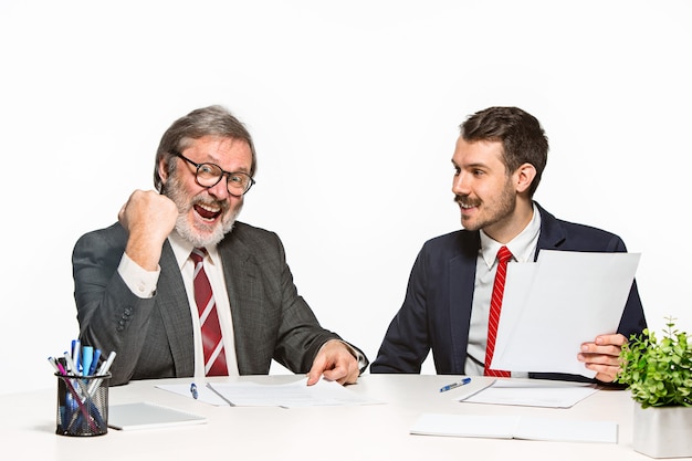 Los dos colegas que trabajan juntos en la oficina en blanco.