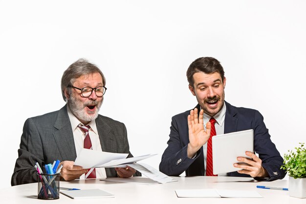 Los dos colegas que trabajan juntos en la oficina en blanco.