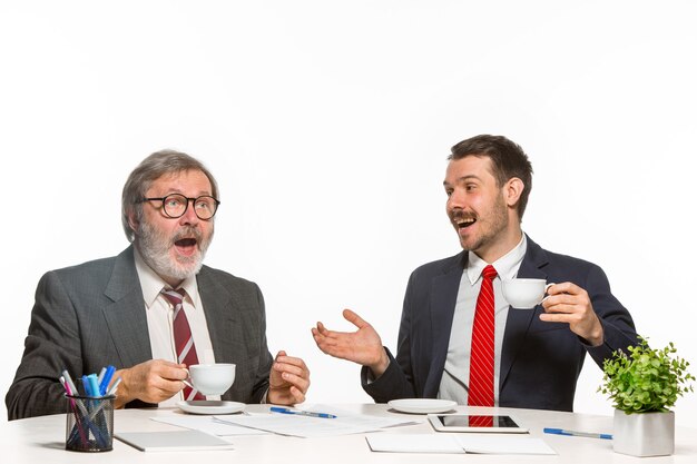 Los dos colegas que trabajan juntos en la oficina en blanco.