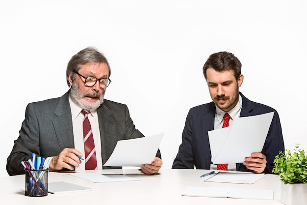 Los dos colegas que trabajan juntos en la oficina en el estudio blanco