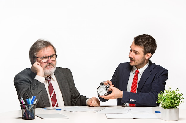 Los dos colegas que trabajan juntos en la oficina sobre fondo blanco.