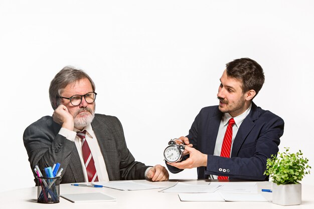 Los dos colegas que trabajan juntos en la oficina sobre fondo blanco.