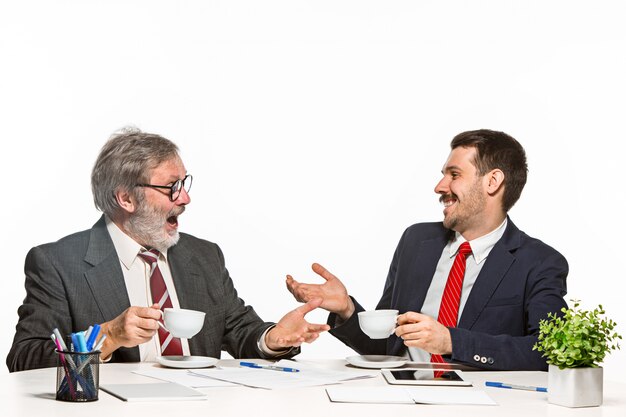 Los dos colegas que trabajan juntos en la oficina sobre fondo blanco.