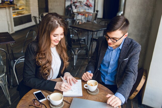 Dos colegas sentados discutir un proyecto en un café