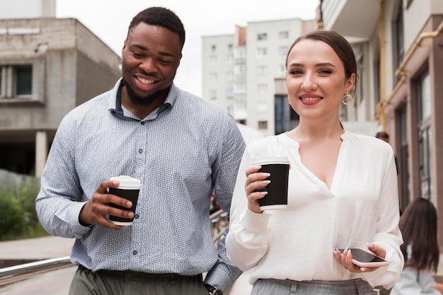 Dos colegas sonrientes tomando café juntos en el trabajo