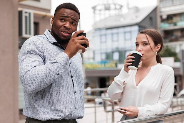 Foto gratuita dos colegas tomando café juntos en el trabajo durante la pandemia