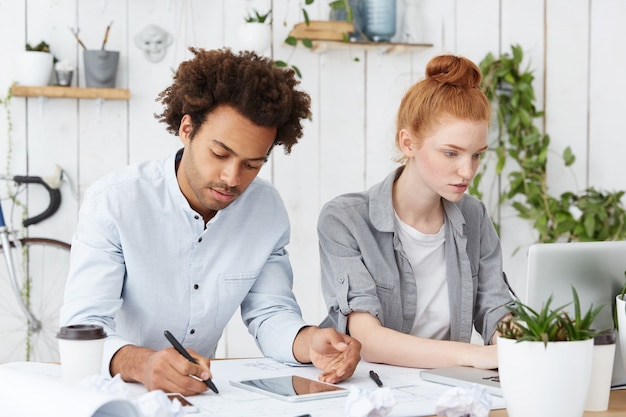 Dos compañeros de trabajo arquitectos trabajando duro, frente a la fecha límite