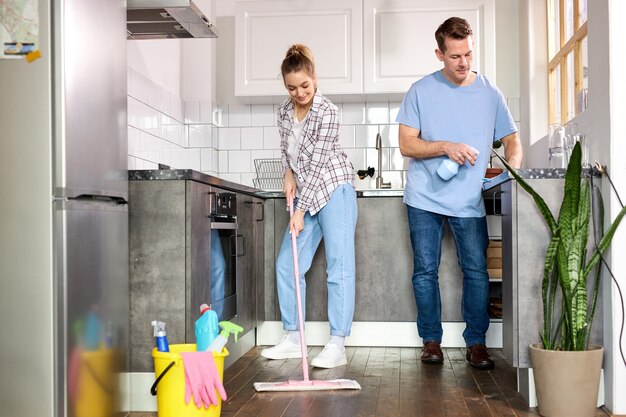 Hombre limpiando el piso con aspiradora en la moderna sala de estar