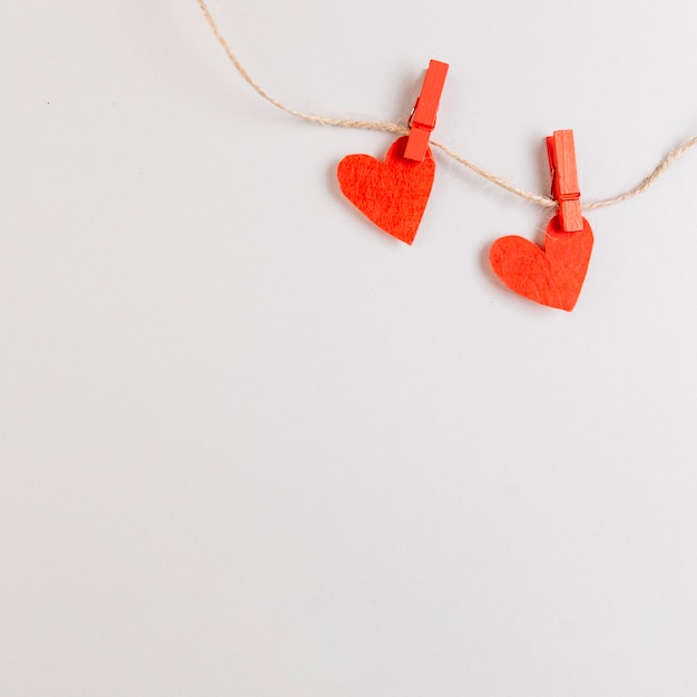 Foto gratuita dos corazones rojos en una cuerda con alfileres