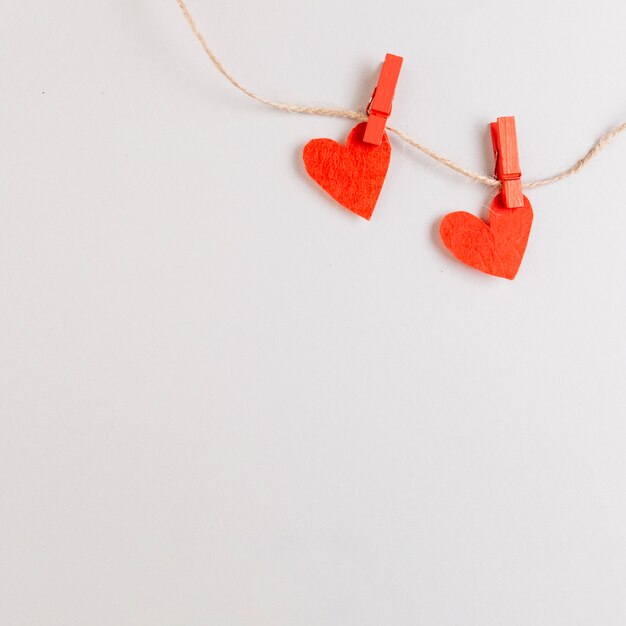 Dos corazones rojos en una cuerda con alfileres