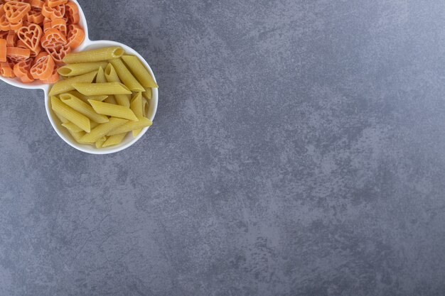 Dos cuencos de pasta varia sobre fondo de piedra.