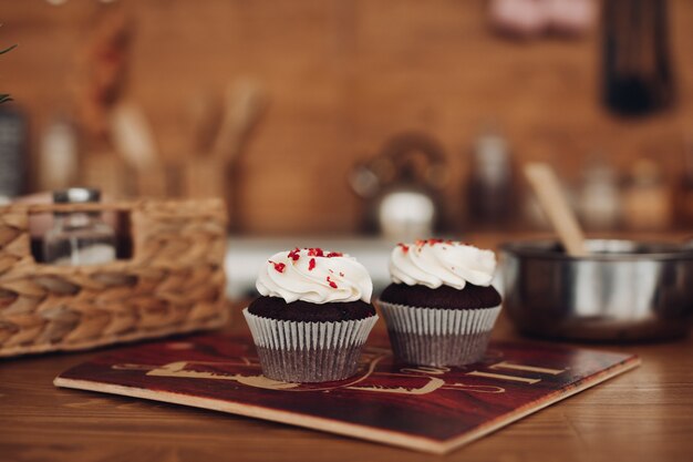 Dos deliciosos cupcackes de chocolate con crema blanca