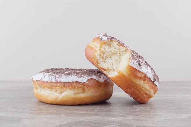 Dos donas glaseadas sobre mármol