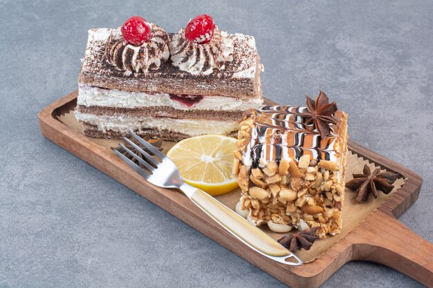 Dos dulces deliciosos trozos de pasteles con anís estrellado sobre tabla de madera.