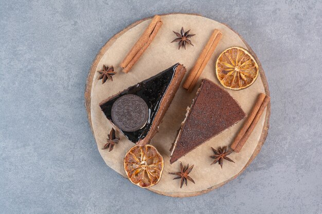 Dos dulces deliciosos trozos de pasteles con anís estrellado sobre tabla de madera.