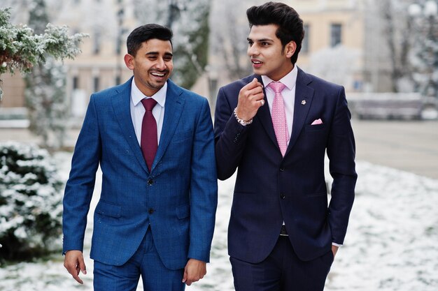 Dos elegantes modelos indios de moda en traje posan en el día de invierno