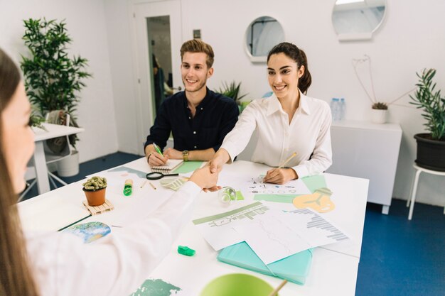 Dos empresaria feliz estrecharme la mano durante la reunión de negocios