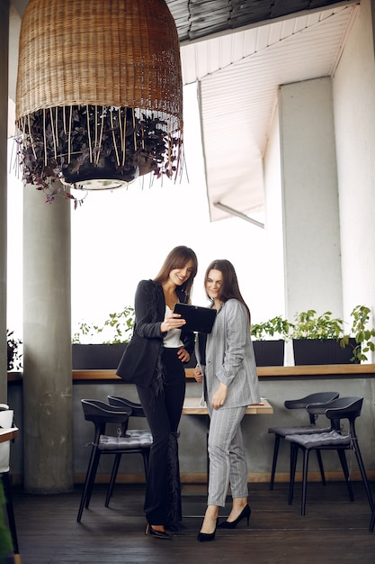 Foto gratuita dos empresarias trabajando en una cafetería