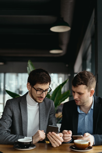 Dos empresarios conversando con un teléfono inteligente