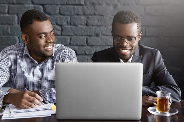 Dos empresarios discutiendo datos financieros en tableta digital