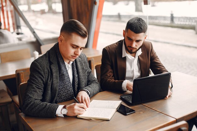 Dos empresarios trabajando en una cafetería.