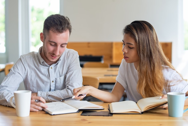 Foto gratuita dos estudiantes estudiando y haciendo tareas juntos.