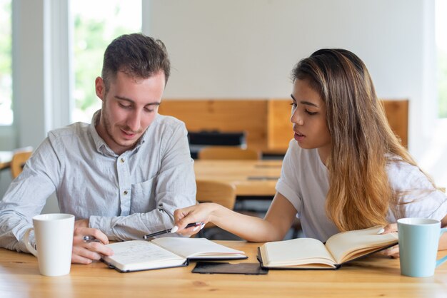 Dos estudiantes estudiando y haciendo tareas juntos.