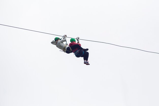 Dos excursionistas en tirolina aventura contra el cielo en costa rica