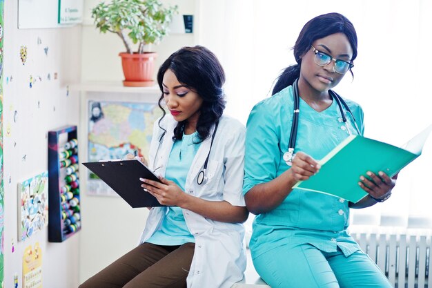 Dos farmacéuticos afroamericanos que trabajan en una farmacia en la farmacia del hospital Atención sanitaria africana