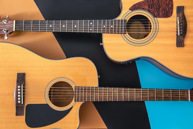 Dos guitarras acústicas sobre un fondo de color plano