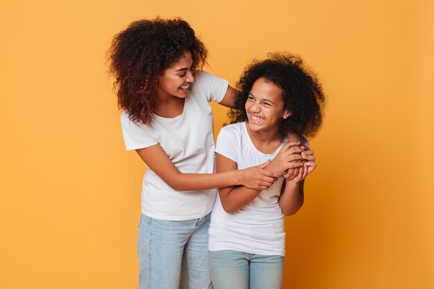 Dos hermanas afroamericanas felices divirtiéndose mientras está de pie