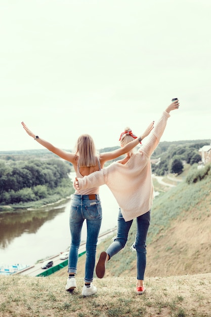 Dos hermanas de chicas jóvenes posando en la calle, hacen selfie