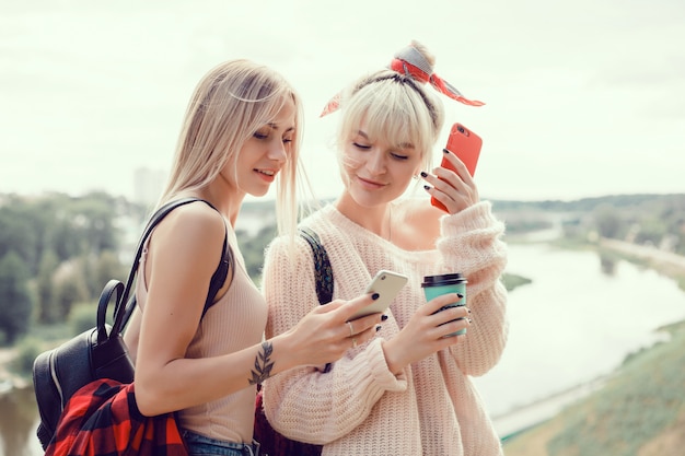 Dos hermanas de chicas jóvenes posando en la calle, hacen selfie