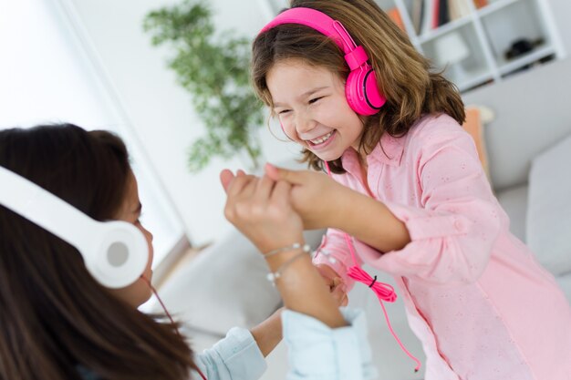 Dos hermanas jóvenes que escuchan la música y el baile en el país.