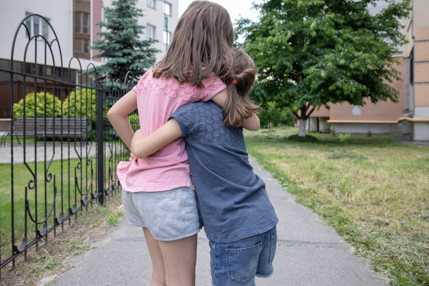 Dos hermanas pequeñas novias abrazan en un paseo en el verano
