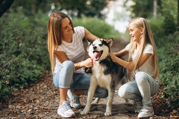 Dos hermanas con su perro en el parque.