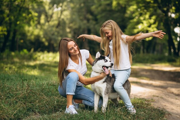 Dos hermanas con su perro en el parque.