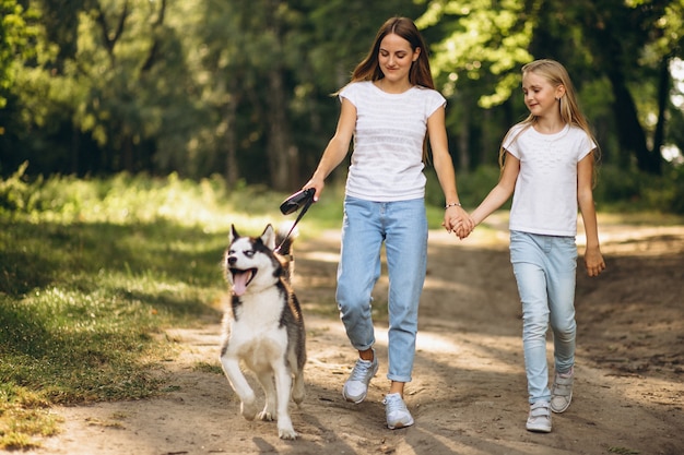 Dos hermanas con su perro en el parque.