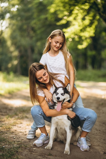 Dos hermanas con su perro en el parque.