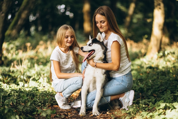 Dos hermanas con su perro en el parque.