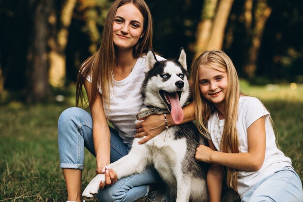 Dos hermanas con su perro en el parque.