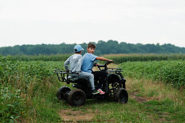 Dos hermanos conduciendo fourwheller ATV quad bike Momentos de niños felices